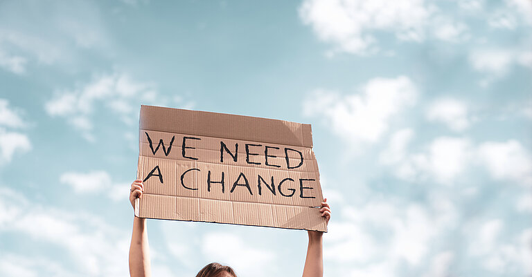 Sign with Slogan  "We need a change" written on it. © Getty Images / DA4554