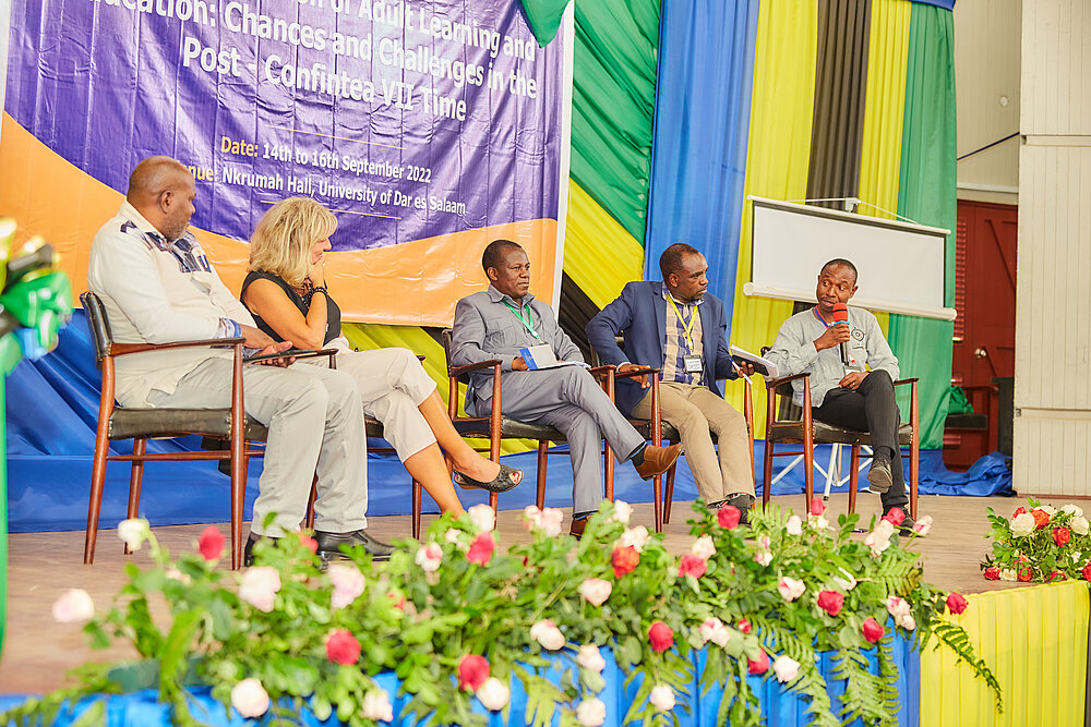 Persons on a stage in a discussion in front of audiience