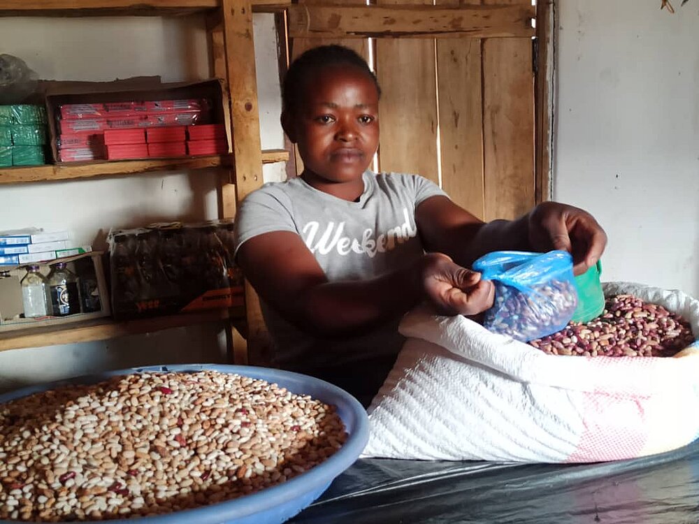 Eine Frau verkauft Bohnen. Sie ist eine Begünstigte des Projekts Integrated Adult Education for Entrepreneurship © Angella Phiri