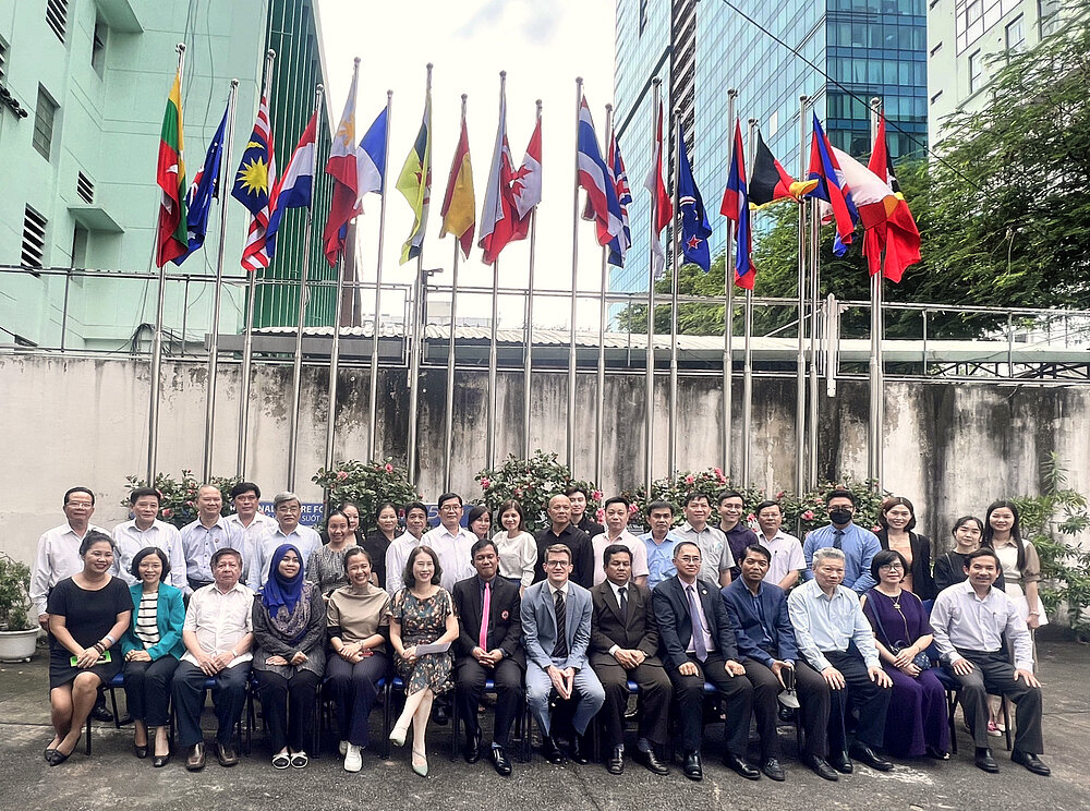 Group photograph: Experts on Adult Education in front of flags, Ho Chi Minh City