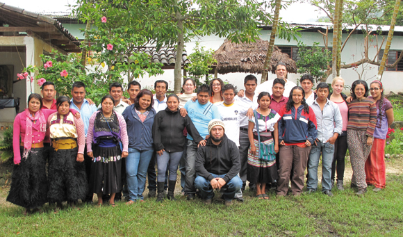 Many people pose for a group photo outdoors.